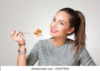 Beautiful young brunette woman eating Italian pasta.