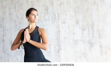 Beautiful Young Brunette Woman Yoga Instructor Doing Vrikshasana On A Mat In A Wooden Floor Standing In The Gym With Day Lighting