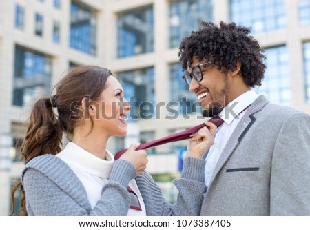 Beautiful young business couple fooling around while smiling