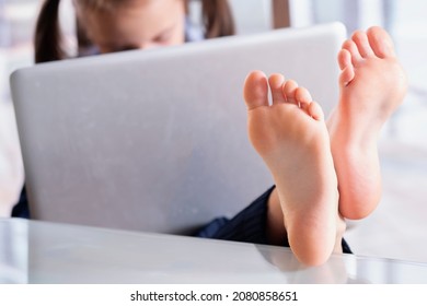 Schöne junge Geschäftsfrau, die im Büro arbeitet, Füße auf dem Schreibtisch. Selektiver Fokus auf die Füße. Kopiert Platz.