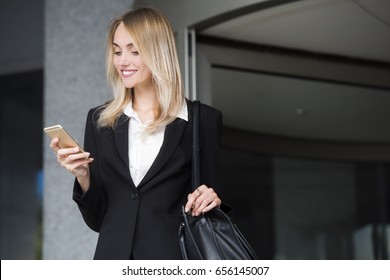 Beautiful Young Business Woman Executive Is Using An Application In Her Smart Phone To Check Email Or Send A Text Message