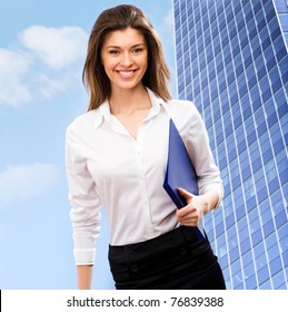 A Beautiful Young Business Woman In A Field With A Blue Sky