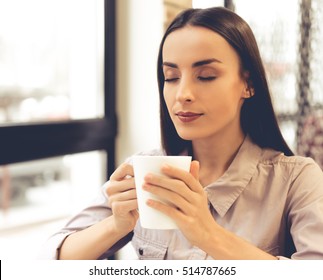 Beautiful young business woman is holding a cup having a break during her work in office - Shutterstock ID 514787665