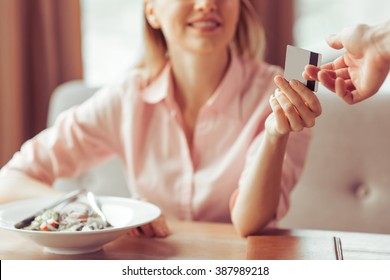 Beautiful Young Business Woman Is Paying With A Credit Card For Business Lunch At The Restaurant, Close-up