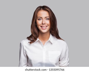 Beautiful Young Business Woman Portrait. Smiling Cute Girl With Long Hair Studio Shot. Isolated On Gray Background