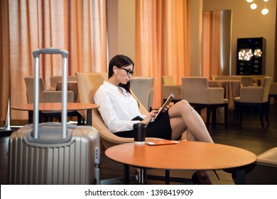 Beautiful young business woman working on computer in a hotel lobby
