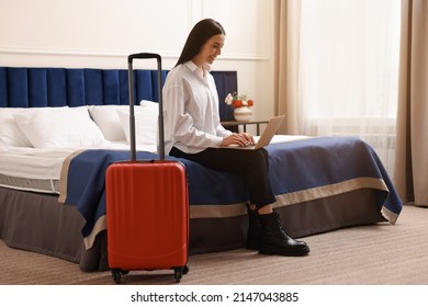 Beautiful Young Business Woman Working With Laptop On Bed In Hotel Room