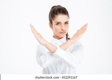 Beautiful young businesswoman with crossed hands showing stop gesture over white background - Shutterstock ID 452291167