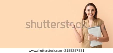 Beautiful young businesswoman holding documents on beige background with space for text