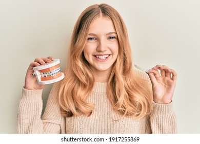 Beautiful Young Caucasian Girl Holding Invisible Aligner Orthodontic And Braces Smiling With A Happy And Cool Smile On Face. Showing Teeth. 