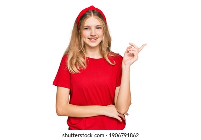 Beautiful Young Caucasian Girl Wearing Casual Red T Shirt With A Big Smile On Face, Pointing With Hand And Finger To The Side Looking At The Camera. 