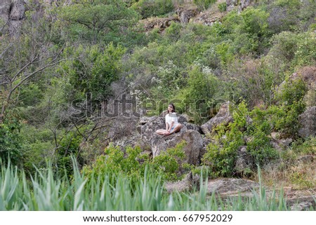 Similar – Beautiful young woman thinking and sitting on the rocks outdoors on the countryside