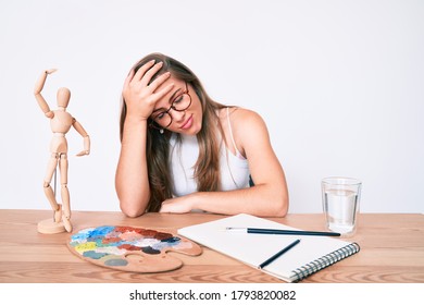 机の上に座っている美しい白人の若い女性画家は、間違って頭に手を置いて驚き、間違いを思い出す。 忘れた、メモリのコンセプトが悪い。 
