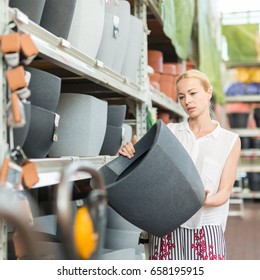 Beautiful Young Caucasian Woman Choosing The Right Item For Her Apartment In A Modern Home Decor Furnishings Store. Shopping In Retail Store.