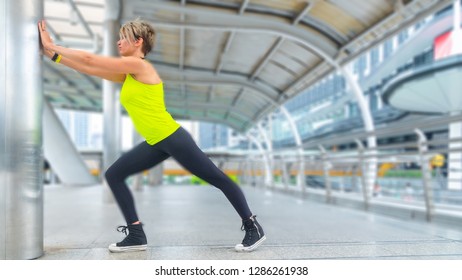 Beautiful young caucasian woman in fitness wear doing exercises at outdoor city. - Shutterstock ID 1286261938