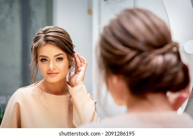 Beautiful Young Caucasian Woman Looking At Her New Haircut In The Mirror Touches Hairstyle