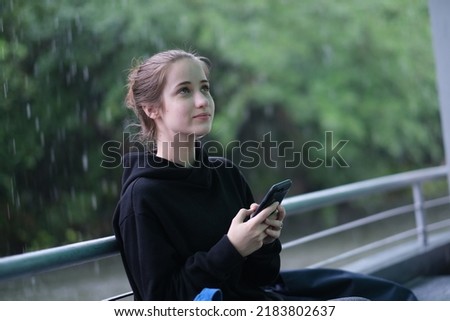 Image, Stock Photo Blonde woman looking at her smartphone outdoors