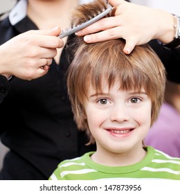 Beautiful young child with large expressive eyes at the hairdresser having a haircut