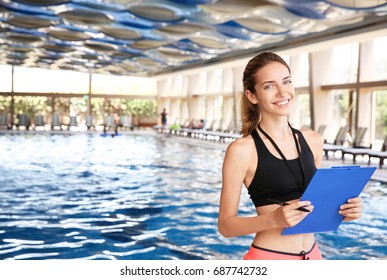 Beautiful Young Coach Holding Clipboard Near Swimming Pool