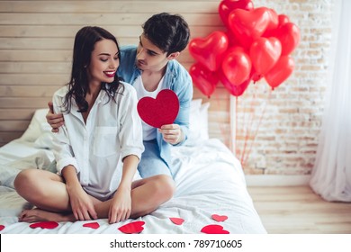 Beautiful young couple in bedroom. Celebrating Saint Valentine's Day.