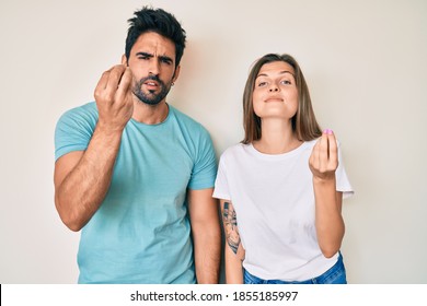 Beautiful young couple of boyfriend and girlfriend together doing italian gesture with hand and fingers confident expression 