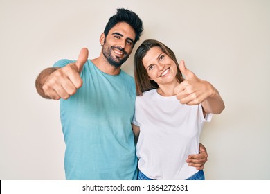 Beautiful young couple of boyfriend and girlfriend together approving doing positive gesture with hand, thumbs up smiling and happy for success. winner gesture.  - Shutterstock ID 1864272631