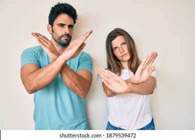 Beautiful young couple of boyfriend and girlfriend together rejection expression crossing arms doing negative sign, angry face 