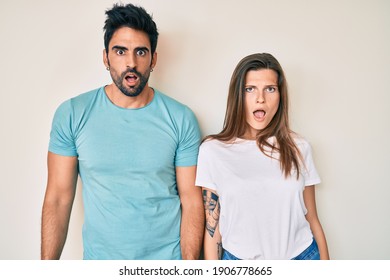 Beautiful young couple of boyfriend and girlfriend together in shock face, looking skeptical and sarcastic, surprised with open mouth  - Shutterstock ID 1906778665
