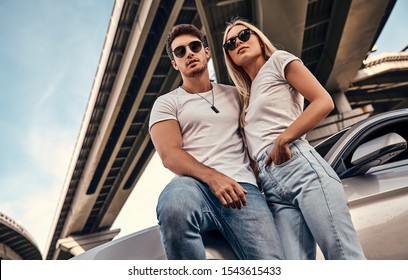 Beautiful Young Couple In Casual Clothes Near Sport Car.