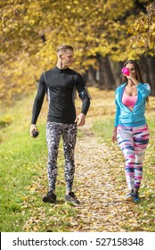 Beautiful Young Couple Cooling Down After Running In The Park. Autumn Environment.