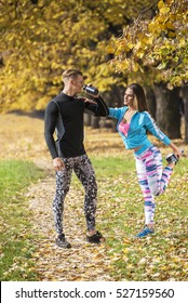 Beautiful Young Couple Cooling Down After Running In The Park. Autumn Environment.