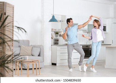 Beautiful Young Couple Dancing In Kitchen At Home