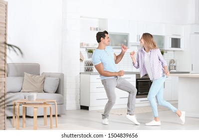 Beautiful Young Couple Dancing In Kitchen At Home