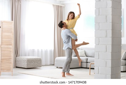 Beautiful young couple dancing in living at home