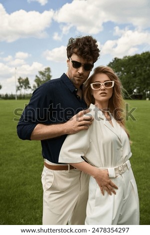 Similar – Image, Stock Photo A fashionable couple, dressed in white and wearing avant-garde shoes, is having some fun in the green meadow. With a cow. It’s a great outdoor wanderlust at its best. On a wild summer night.