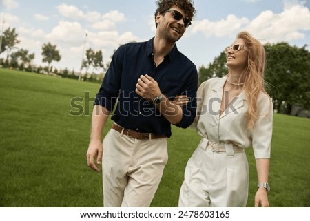 Similar – Image, Stock Photo A fashionable couple, dressed in white and wearing avant-garde shoes, is having some fun in the green meadow. With a cow. It’s a great outdoor wanderlust at its best. On a wild summer night.