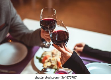 Beautiful young couple with glasses of red wine in luxury restaurant - Shutterstock ID 364873787