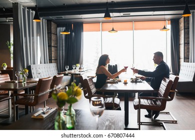 Beautiful Young Couple With Glasses Of Red Wine In Luxury Restaurant