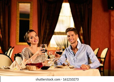 Hermosa pareja joven con copas de vino en el restaurante