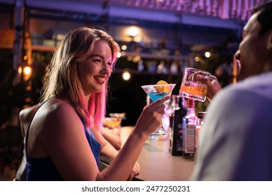 Beautiful young couple having fun, drinking alcohol cocktail in a bar. Attractive friend man and woman feeling happy and relax having a party, drink a glass of beer to celebrating event at night club. - Powered by Shutterstock