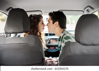 Beautiful young couple having fun inside a car