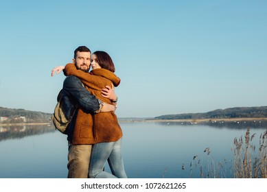 beautiful young couple in hipster clothes hugging in the background beautiful blue lake, beautiful loving feeling - Powered by Shutterstock