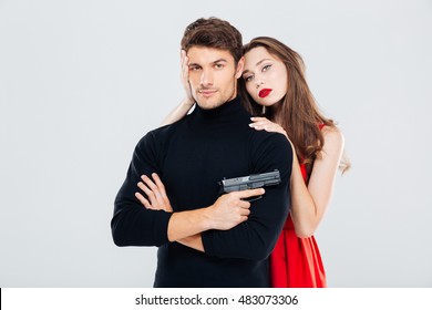 Beautiful young couple hugging and posing with gun