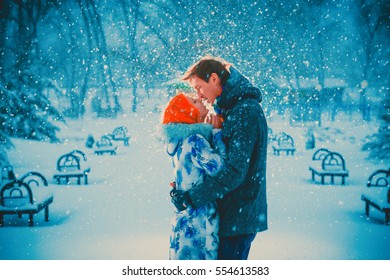 beautiful young couple kiss on snow park background
