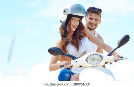 Beautiful young couple in love enjoying and having fun riding on a scooter in a beautiful nature - Powered by Shutterstock