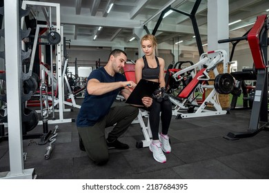 Beautiful Young Couple Of Man And Woman Are Training In The Gym To Keep Fit. The Concept Of A Healthy Lifestyle