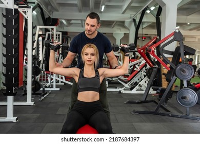 Beautiful Young Couple Of Man And Woman Are Training In The Gym To Keep Fit. The Concept Of A Healthy Lifestyle