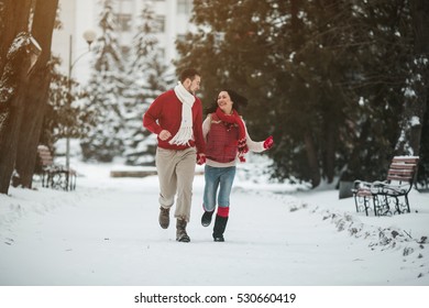 beautiful young couple posing in a snowy park