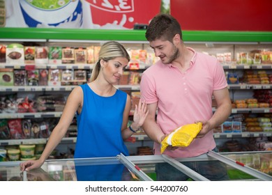 Beautiful Young Couple Shopping For Frozen Fruits And Vegetables In Produce Department Of A Grocery Store - Supermarket - Shallow Deep Of Field