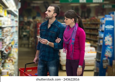 Beautiful Young Couple Shopping For Fruits And Vegetables In Produce Department Of A Grocery Store - Supermarket - Shallow Deep Of Field